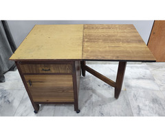 A wooden folding dining table with storage - Image 5/10